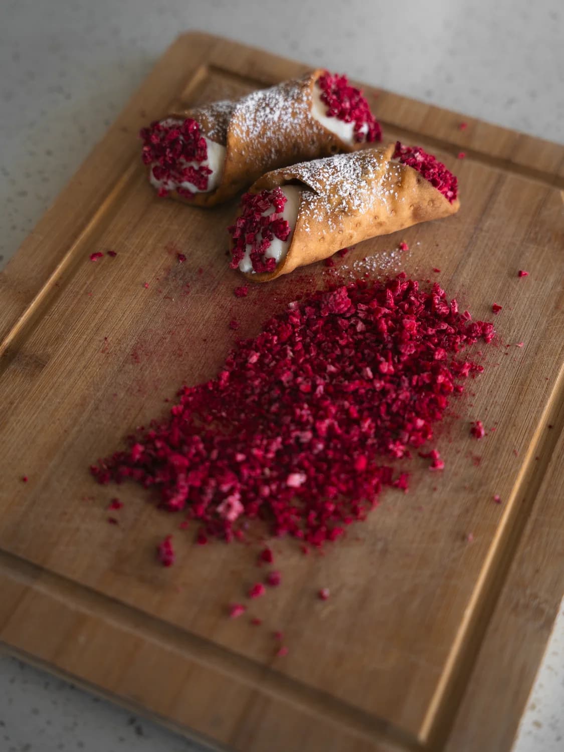 Freshly hand-piped white chocolate raspberry cannolis dusted with powdered sugar — Cannoli Bros catering across Kelowna and the Okanagan