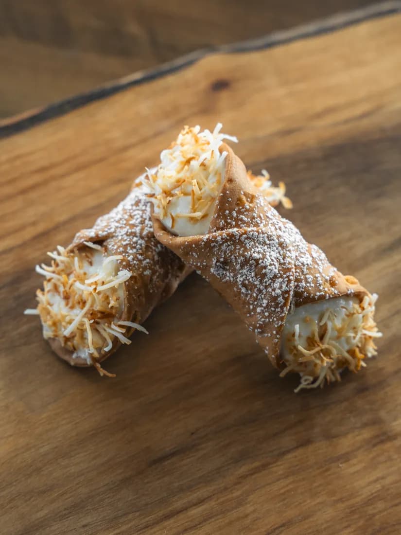 Lemon Ricotta cannoli finished with toasted coconut, hand-piped for Okanagan events by Cannoli Bros
