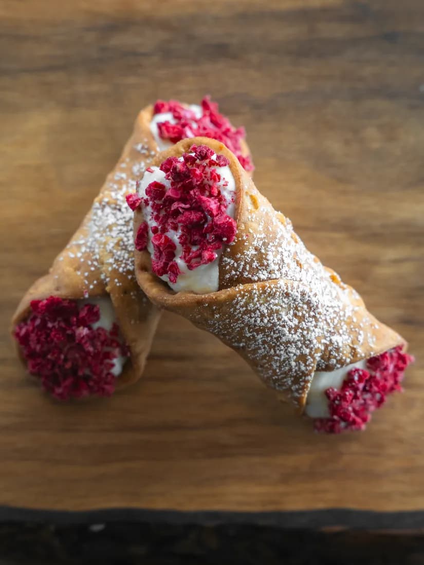 White Chocolate Raspberry cannoli with freeze-dried raspberry powder, hand-finished for Okanagan weddings by Cannoli Bros